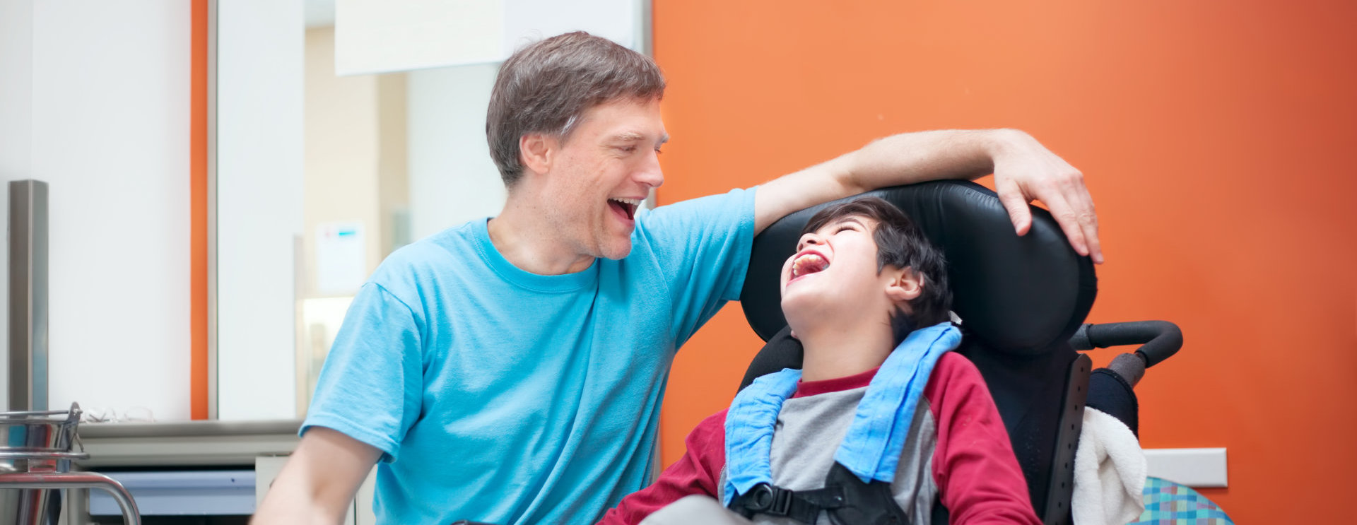man talking with disabled biracial kid